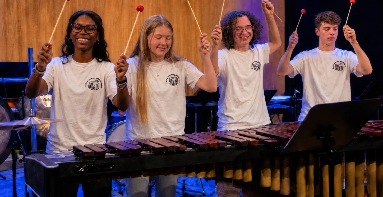 Quattro giovani percussionisti alzano le bacchette dietro la marimba durante il concerto Colibrì in Svizzera